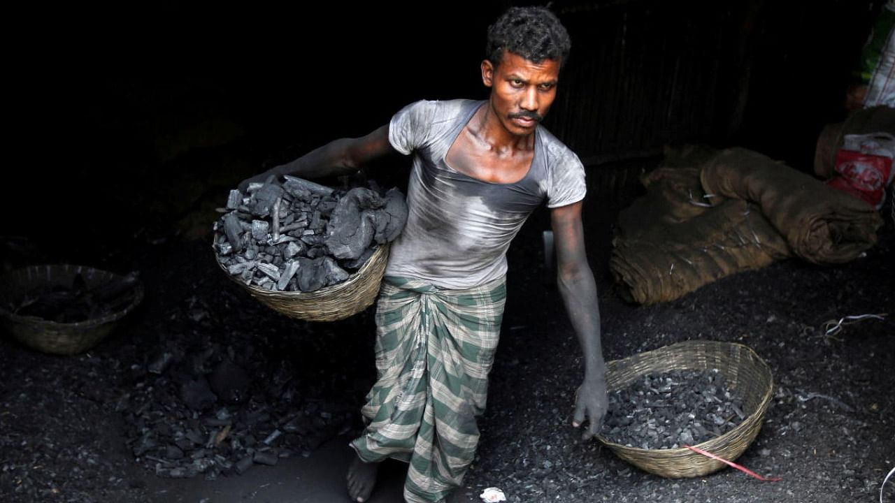  A worker carries coal in a basket in a industrial area in Mumbai. Credit: Reuters Photo