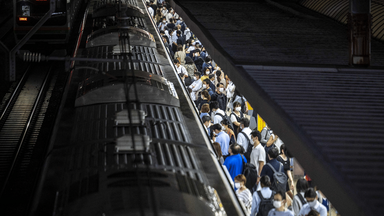Passengers alight and board a train at a station in Tokyo. Credit: AFP Photo
