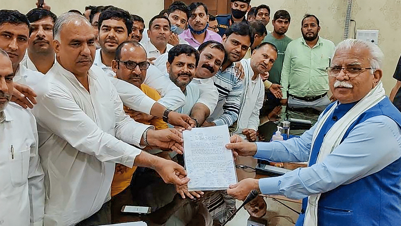 Haryana Chief Minister Manohar Lal Khattar receives a document presented by those facing problems due to the blockade of Tikri and Singhu borders. Credit: PTI Photo