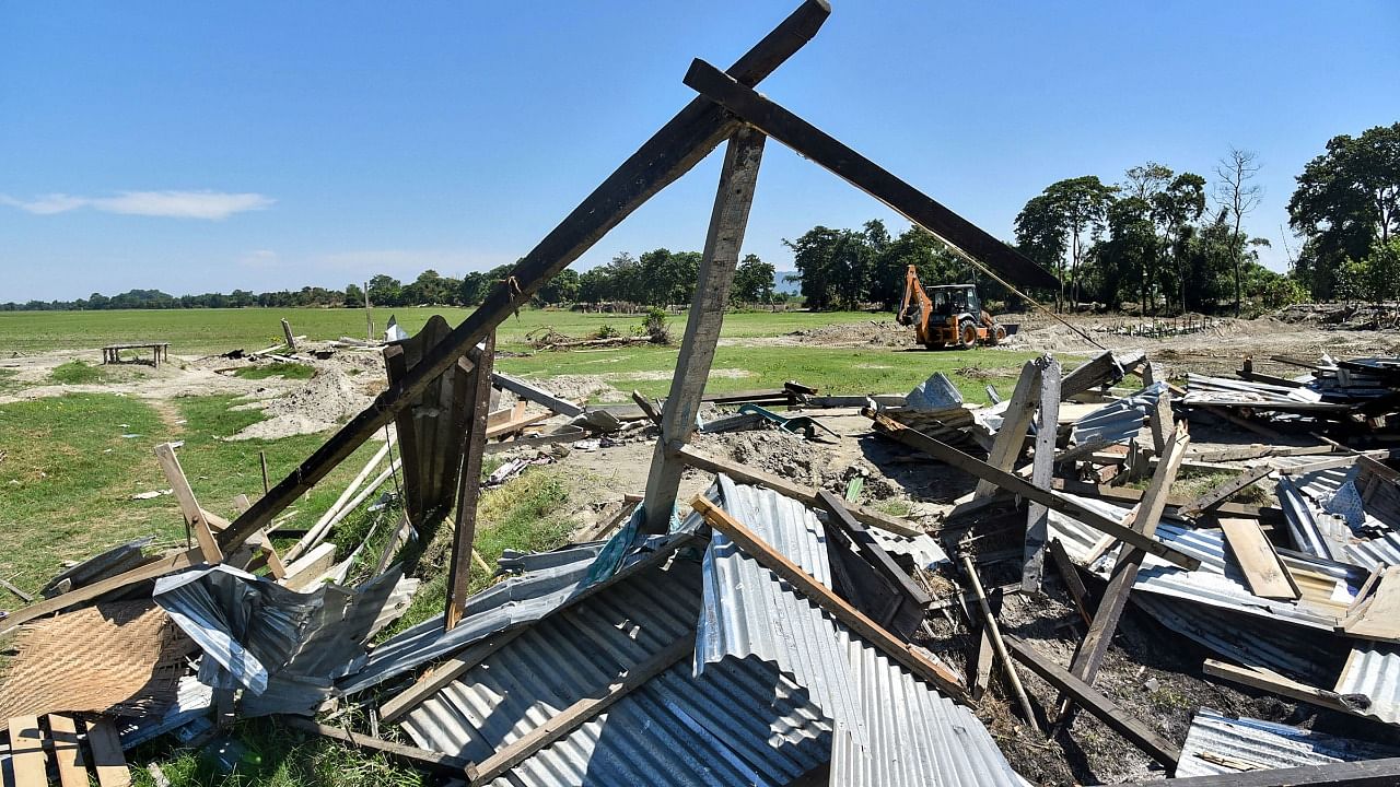 An excavator cleaning demolishes illegal constructions after an eviction drive, at Gorukhuti in Darrang district. Credit: PTI Photo