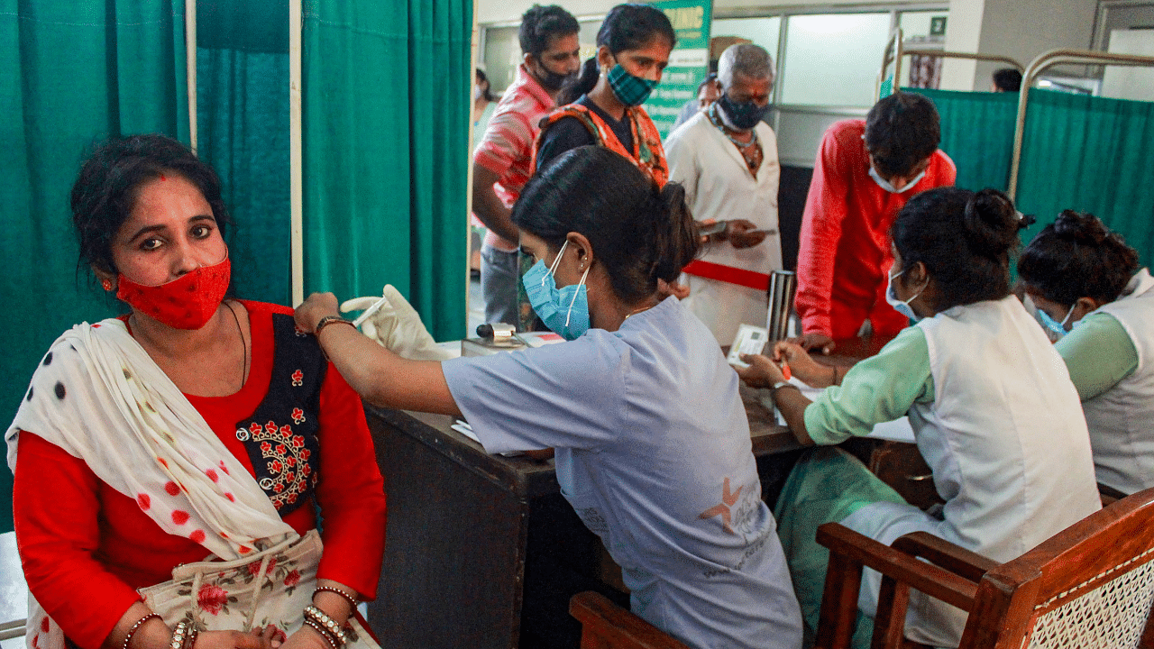 A health worker administers a dose of Covid-19 vaccine to a beneficiary, at Government Polyclinic vaccination centre in Gurugram. Credit: PTI Photo