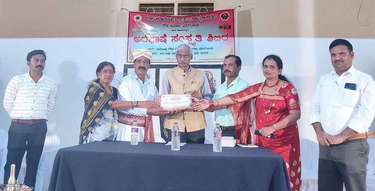 Dignitaries hand over a certificate to a participant of the Arebhashe culture camp organised in Maragodu.