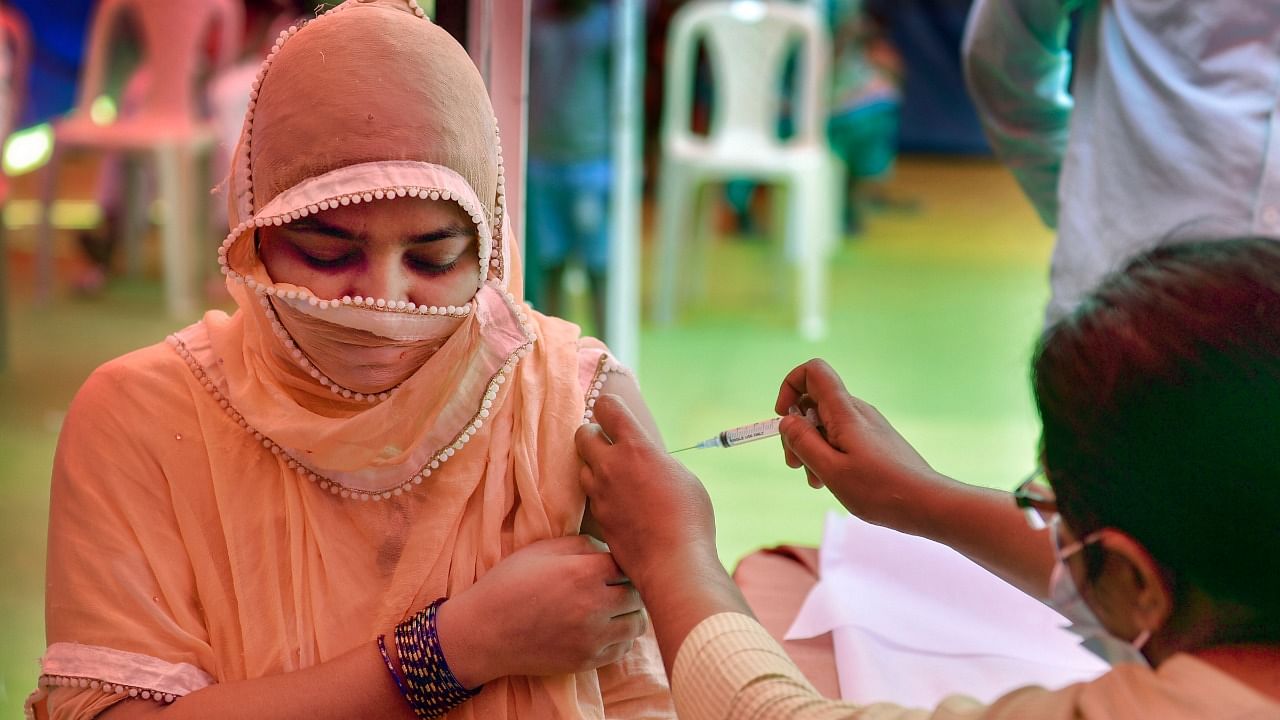 A beneficiary receives Covid-19 vaccine dose, at Bharat Scouts and Guide headquarters, in New Delhi. Credit: PTI File Photo