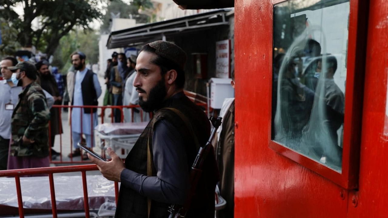 An armed member of Taliban forces stands outside an emergency hospital, after several civilians were killed in an explosion, in Kabul, Afghanistan, October 3, 2021. Credit: Reuters Photo