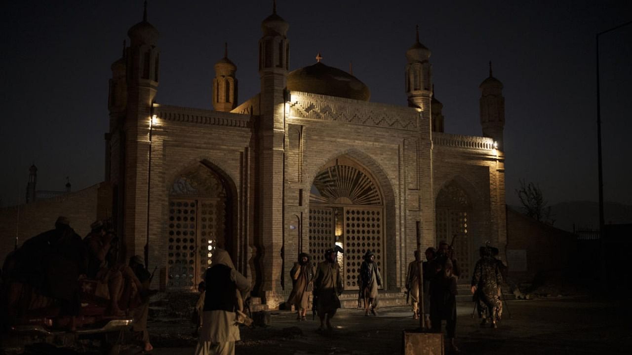 Taliban fighters walk at the entrance of the Eidgah Mosque after an explosion in Kabul. Credit: AP Photo