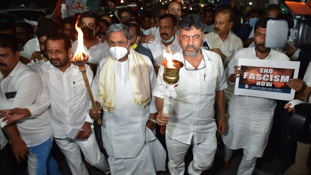 KPCC President D K Shivakumar with former Karnataka chief minister Siddaramaiah and party leaders, holds a torch during a protest against the Lakhimpur Kheri incident. Credit: PTI Photo
