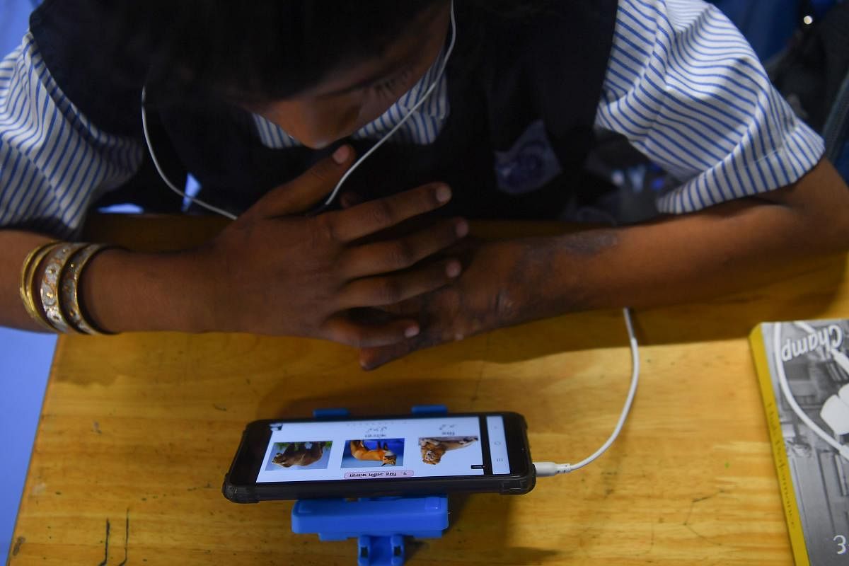 A student accesses e-learning contents on mobile phones during a class in Mumbai. AFP
