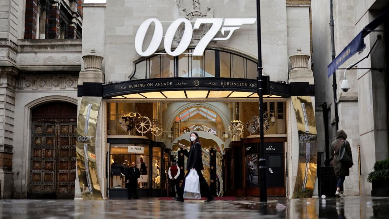  pedestrian walks past a James Bond 007 logo above the entrance to Burlington Arcade in London on October 4, 2021, following the release of the latest James Bond film "No Time To Die". Credit: AFP Photo