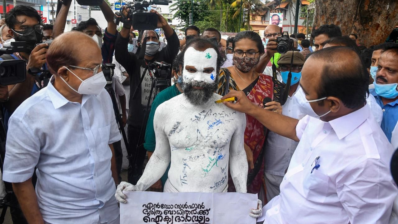 Leader of Opposition in Kerala Assembly VD Satheesan and Dy leader P K Kunhalikutty put their signatures on the painted bare body of a protestor seeking justice for endosulfan victims, in Thiruvananthapuram. Credit: PTI Photo