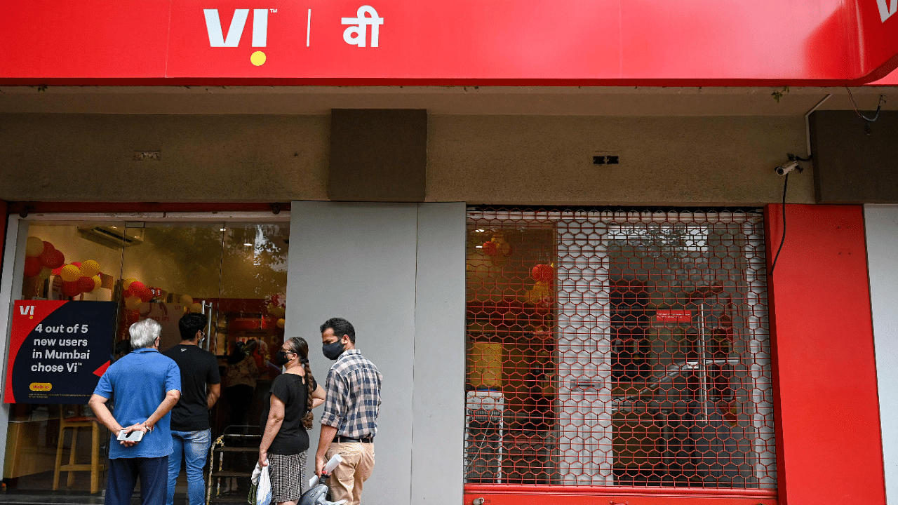 Customers stand in a queue outside the Vodafone-Idea mobile network service provider store. Credit: AFP Photo