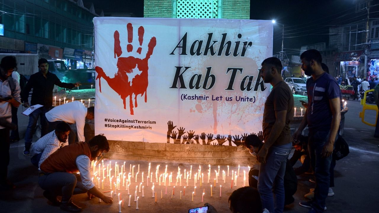 Kashmiri Pandits take part in a candle light protest against the killing of 3 persons including pharmacist ML Bindroo by militants. Credit: PTI Photo