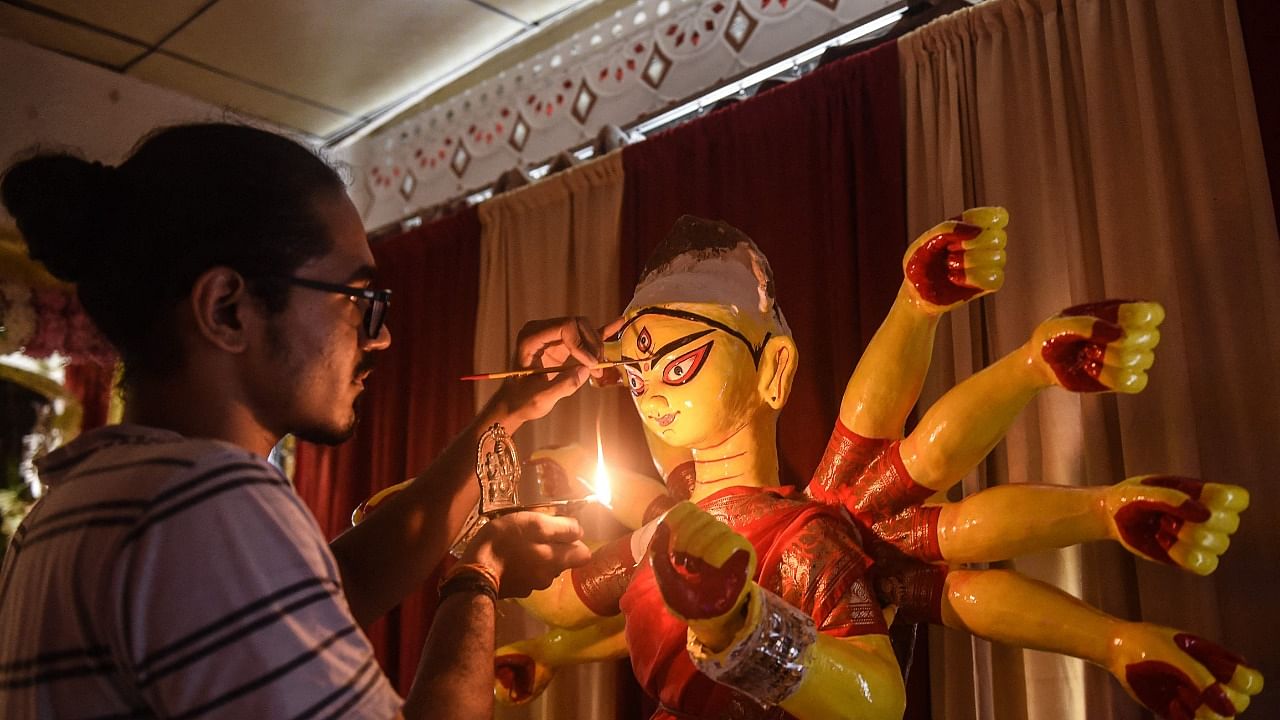 An artist gives the final touches to an idol of Goddess Durga. Credit: AFP Photo