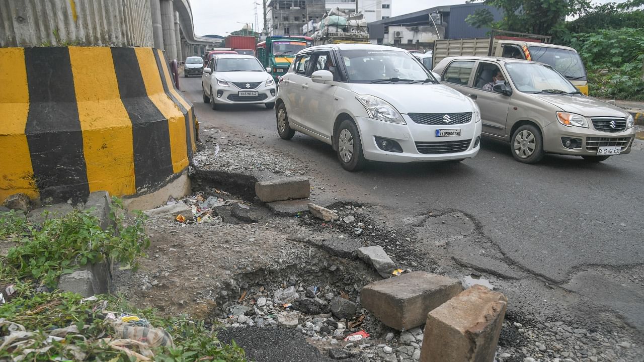The road in and around metro pillar 489 near Jnanabharathi has eroded due to flooding at Mysuru Road in Bengaluru. Credit: DH Photo/S K Dinesh