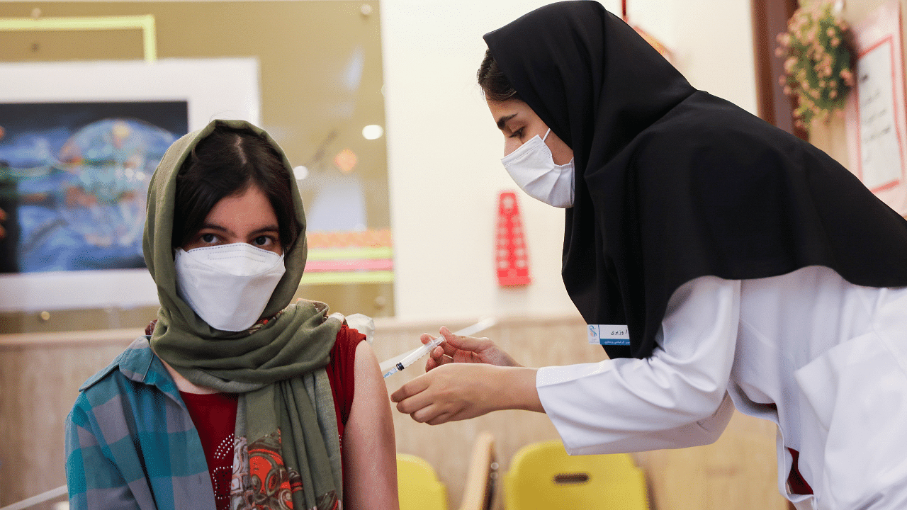 An Iranian teenager receives a dose of a vaccine against the coronavirus disease (Covid-19) at a school in Tehran. Credit: Reuters Photo