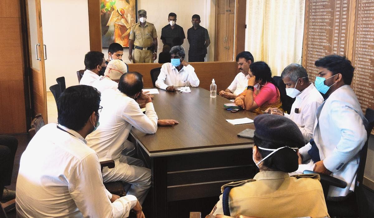 Minister Kota Srinivas Poojary chairs a meeting of elected representatives and district officials in Madikeri on Wednesday. DH Photo