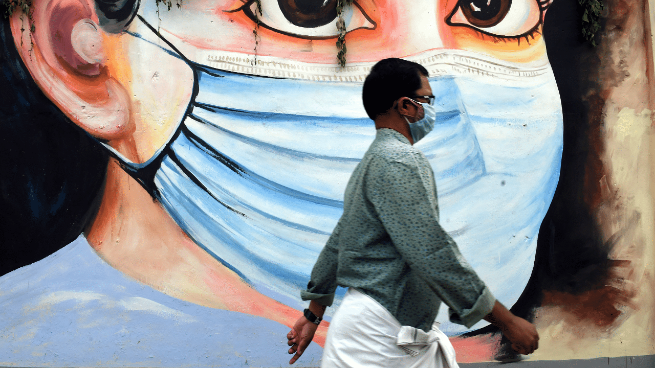 A man walk past a mural on novel coronavirus in Thiruvananthapuram. Credit: PTI Photo