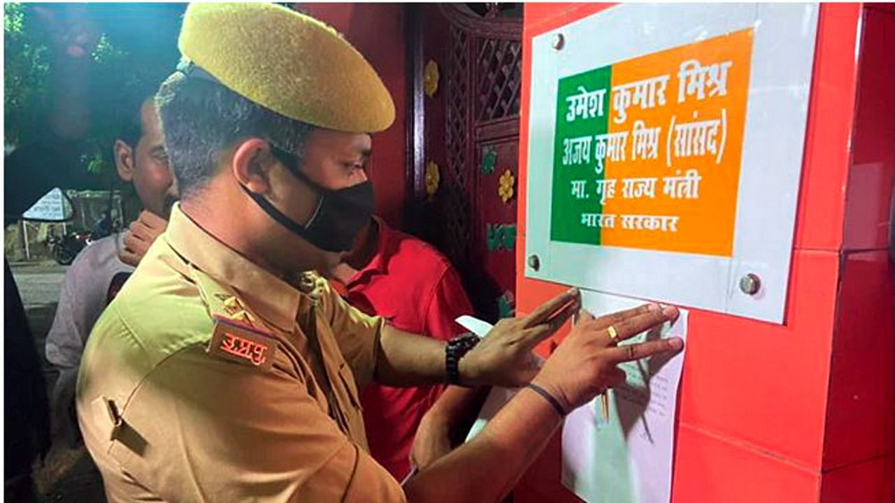 A policeman pastes a notice outside the residence of Union MoS for Home Affairs Ajay Kumar Mishra. Credit: PTI Photo