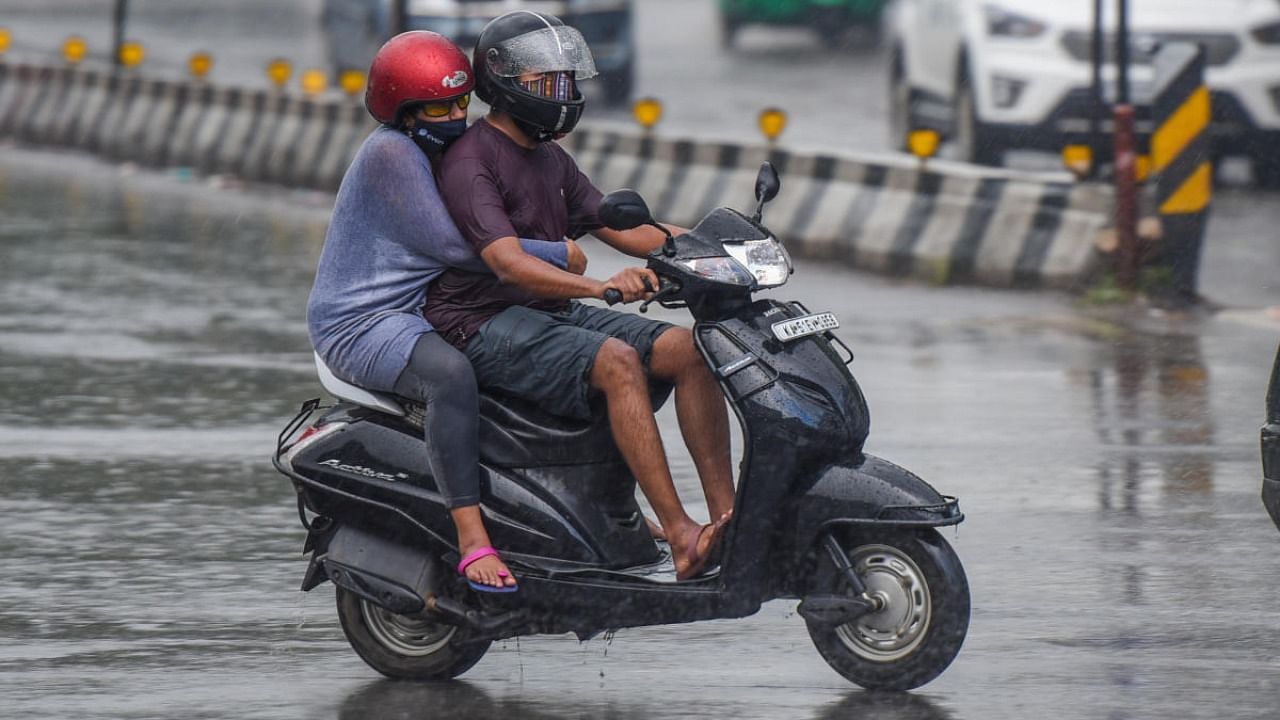 These motorists enjoy riding in the rain along JC Road on Sunday evening. Credit: DH Photo