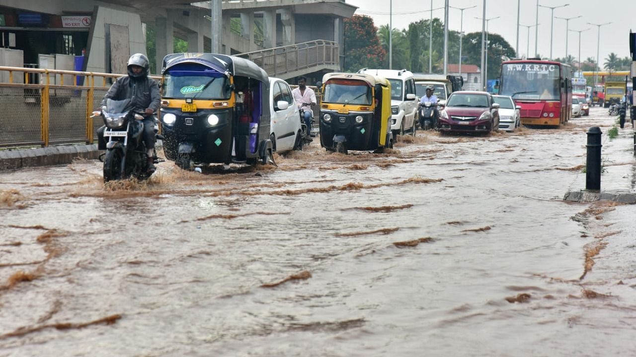 Vehicles stranded in a flooded road as it rained heavily in Hubballi on Monday. DH Photo/Govindaraj Jawali