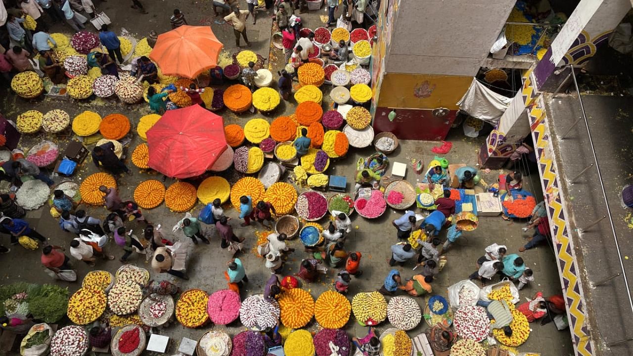 People shop for flowers and ash gourd ahead of the festive season at KR Market on Tuesday. Credit: DH Photo/Pushkar V