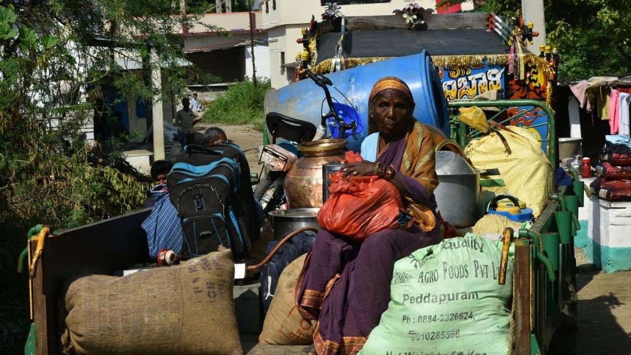 A woman travels out of Gadikeshwar village in a tractor, along with her belongings, following frequent mild tremors. Credit: DH Photo 