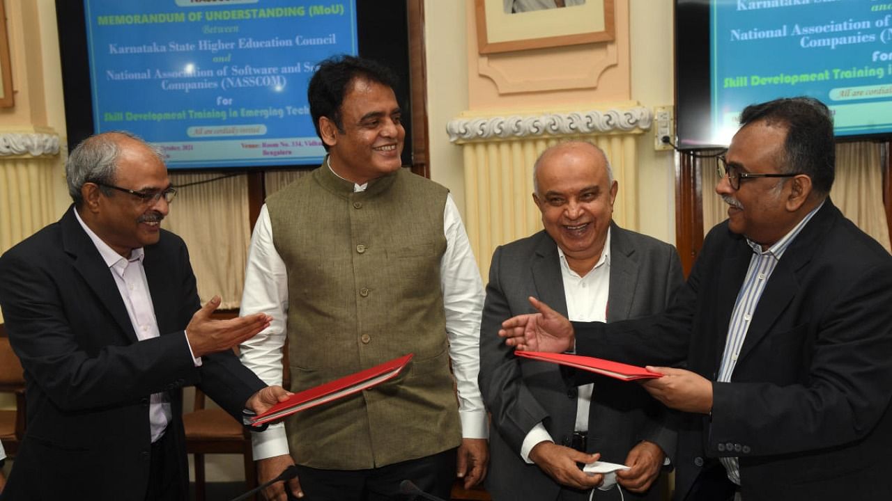Prof. Gopalkrishna Joshi n Executive Director, KSHEC,(Ext. Left) and Navneet Samayar of NASSCOM (Ext. Right) are exchange the Memorandum of Understanding (MoU) was signed in presence of Dr.C.N.Ashwatha Narayana, the Minister for Higher Education and IT/BT. Credit: DH Photo