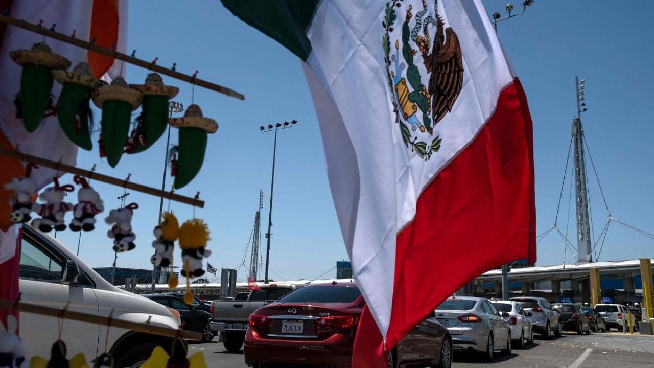 In this file photo taken on June 16, 2020 commuters line up to cross to the United States at the San Ysidro crossing port in Tijuana, Baja California state, Mexico, amid the Covid-19 pandemic. Credit: AFP File Photo