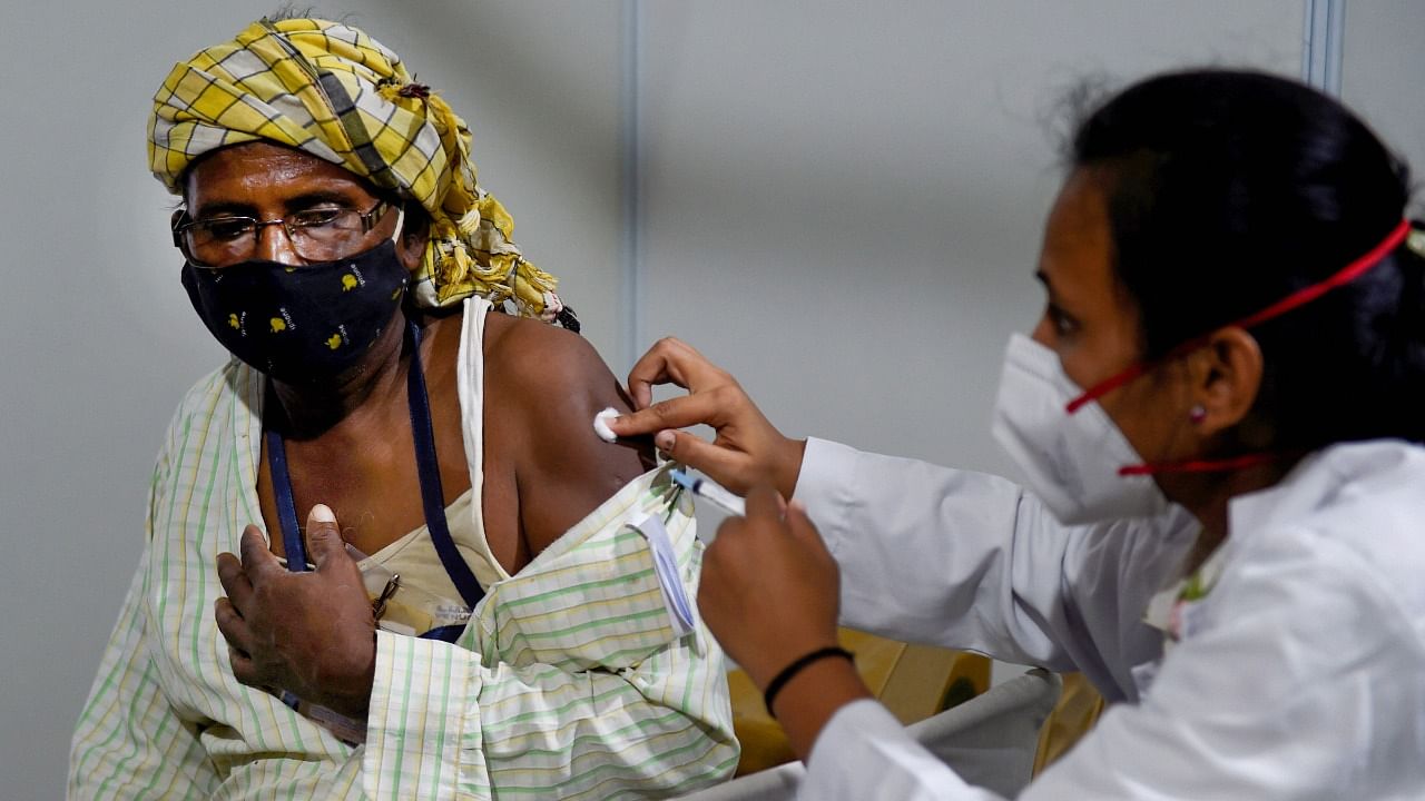 A health worker administers Covid-19 vaccine dose to a beneficiary at a free vaccination camp organised by the Delhi government, in New Delhi. Credit: PTI Photo