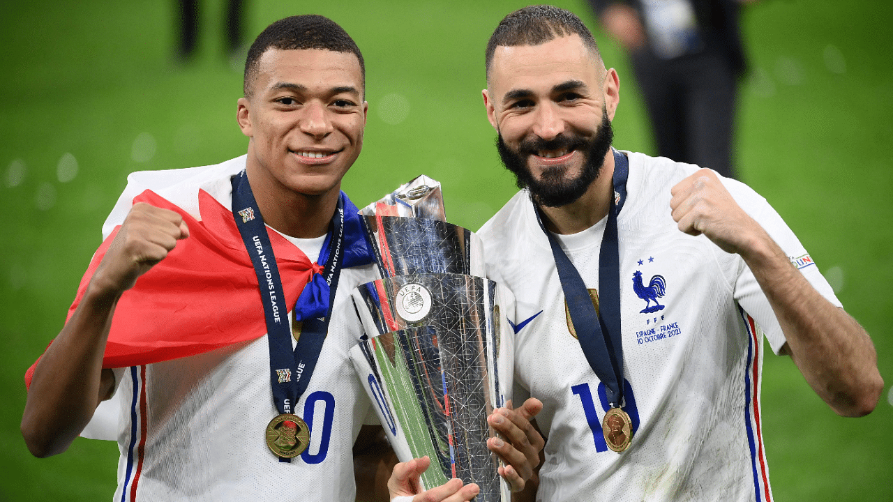 France's forward Kylian Mbappe (L) and France's forward Karim Benzema (R) celebrate with the trophy at the end of the Nations League final football match between Spain and France. Credit: AFP Photo