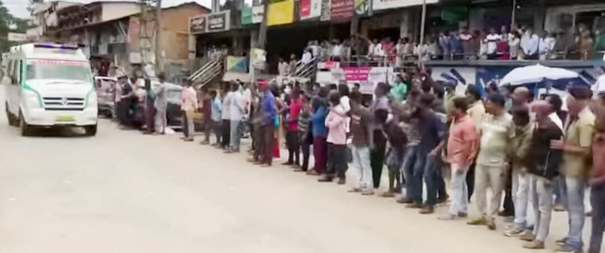 People watch the ambulance as it passes by.