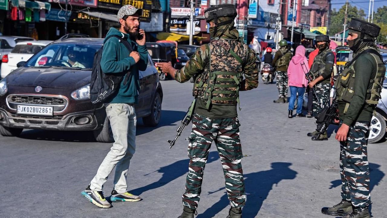 Security personnel stop a pedestrian for frisking along a street in Srinagar, following the killing of two army personnel in an encounter with suspected militants in Poonch district. Credit: AFP Photo