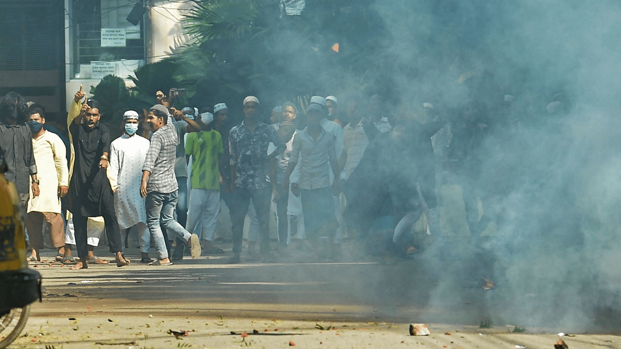 Protesters pelt stones towards police amid tear gas during a demonstration after the Friday prayers near a mosque in Dhaka. Credit: AFP Photo