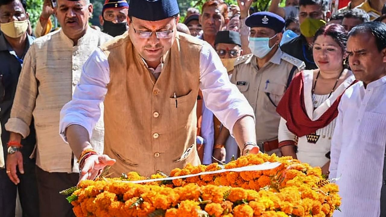 Uttarakhand Chief Minister Pushkar Singh Dhami pays his last respects to martyr Vipin Singh, in Pauri Garhwal, Tuesday, Oct. 12, 2021. Credit: PTI Photo