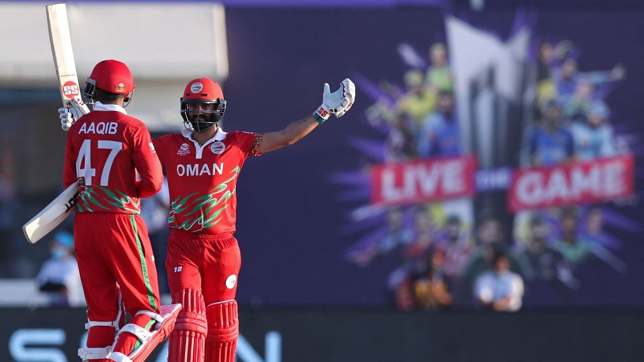 Oman's Jatinder Singh (R) and Aqib Ilyas celebrate their win in the ICC men’s Twenty20 World Cup cricket match between Oman and Papua New Guinea. Credit: AFP Photo