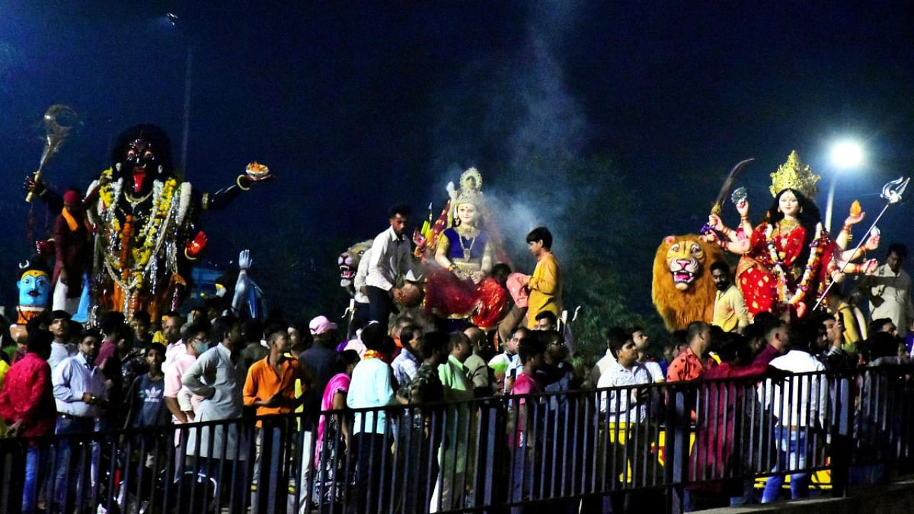 Devotees participate in a procession to immerse idols of Goddess Durga. Credit: PTI Photo