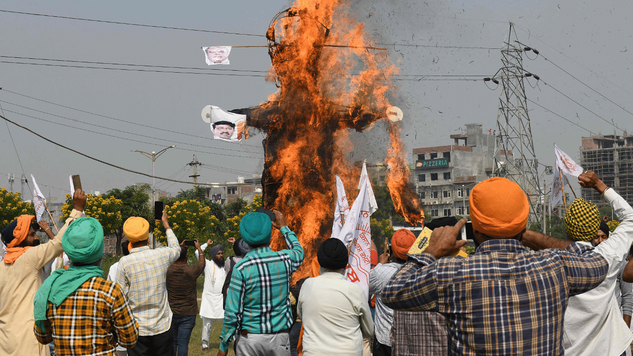 Farmers shout slogans as they burn an effigy with the pictures of India's Prime Minister Narendra Modi. Credit: AFP Photo