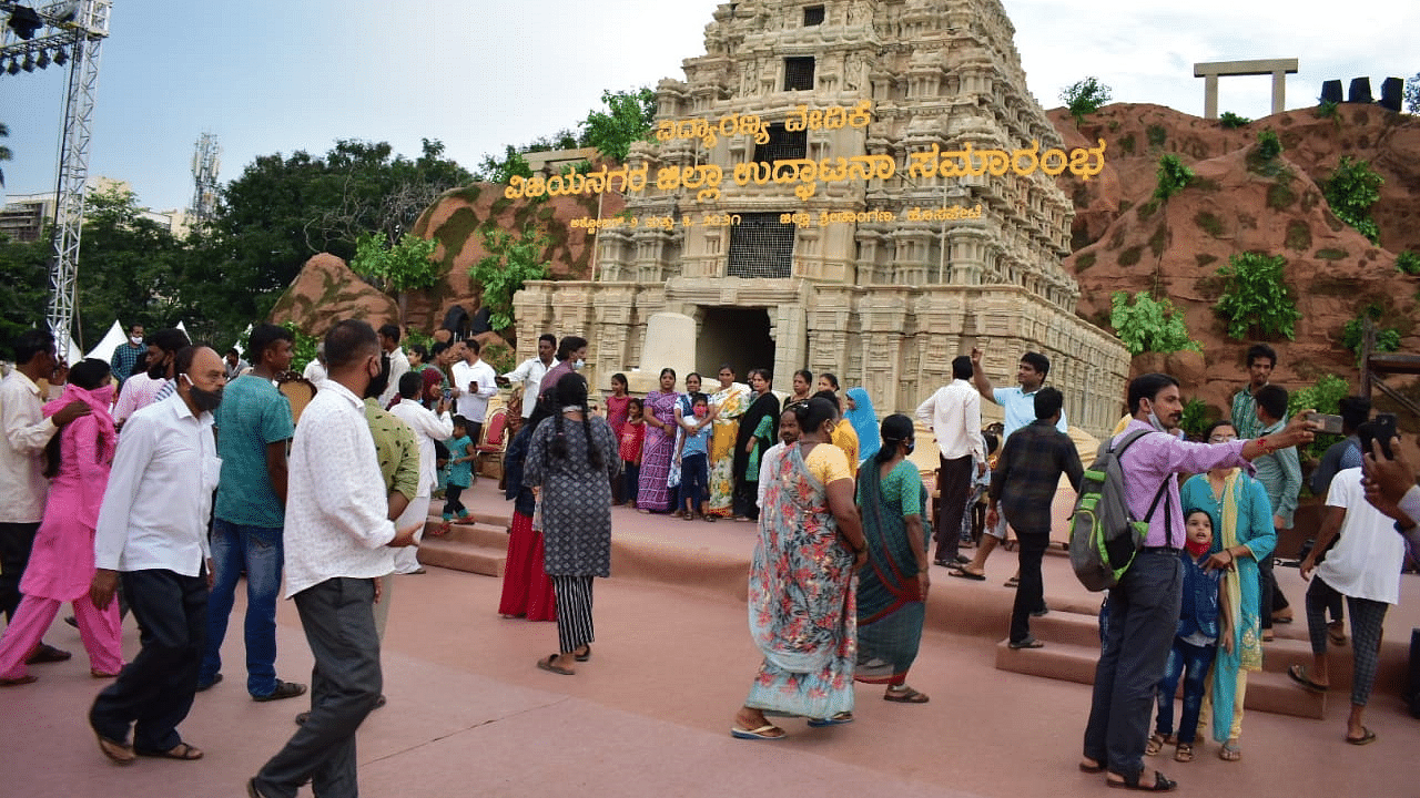 People take selfies in front of a replica of the Hampi temple gopuram ahead of the inauguration of Vijayanagar district in Hosapete. Credit: DH Photo