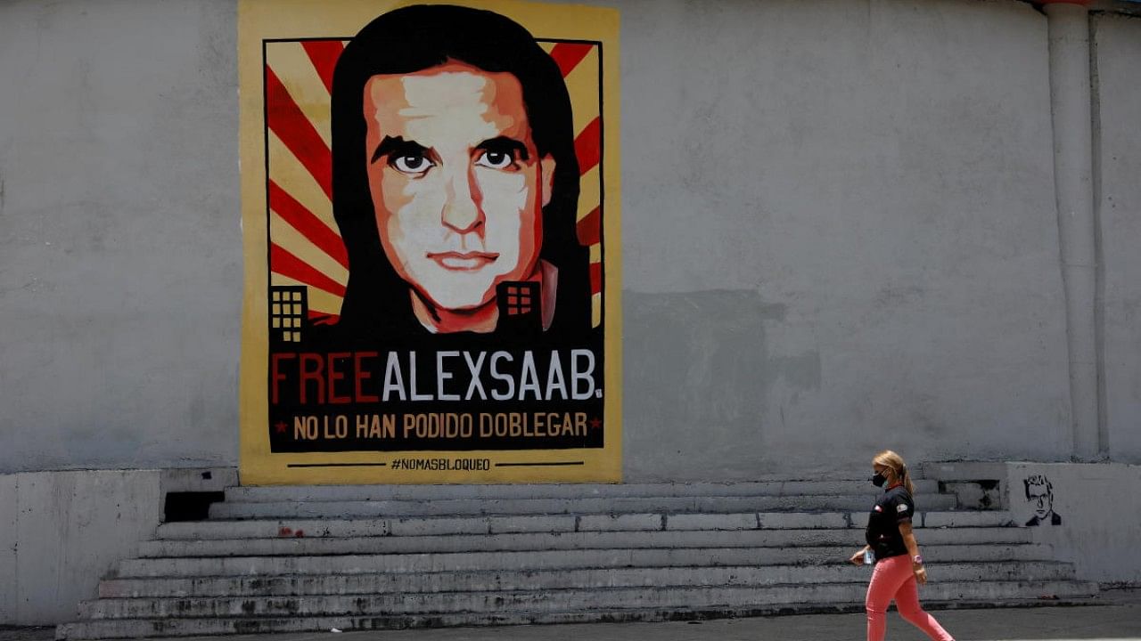  A woman walks by a mural in support of the liberation of businessman Alex Saab, who was detained in Cape Verde on charges of laundering money for the government of Venezuelan President Nicolas Maduro. Credit: Reuters File Photo