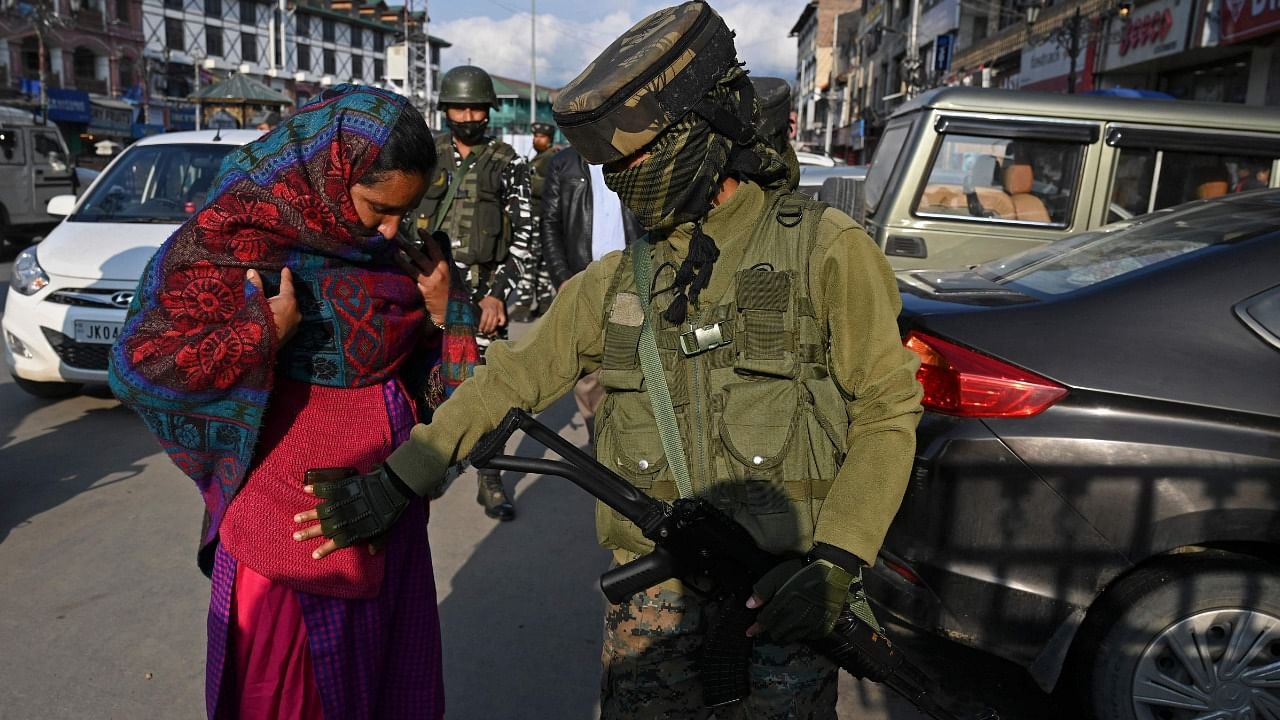 A woman paramilitary trooper frisks a woman during a random search in Srinagar on October 18, 2021, as security has been beefed-up a day after two labourers from Bihar were killed by gunmen, police said. Credit: AFP Photo