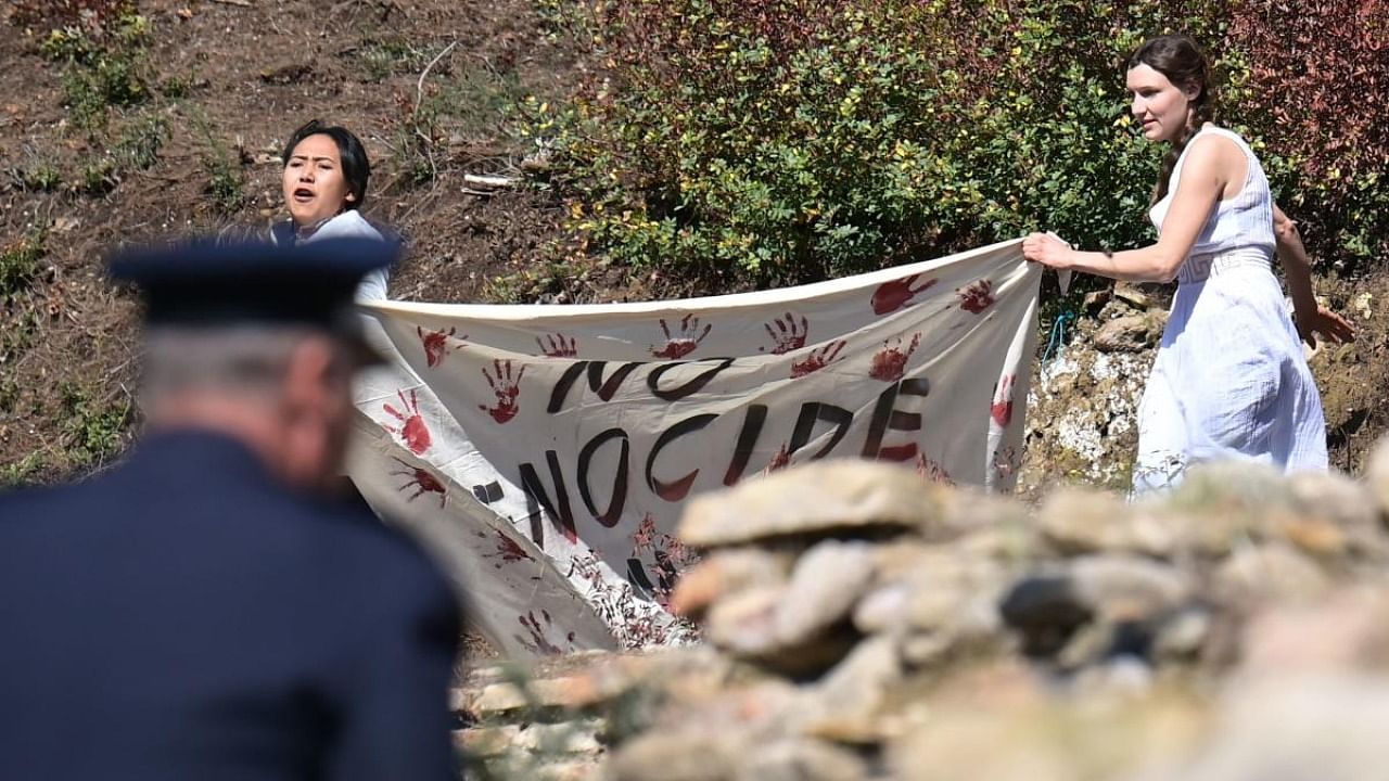 A police officer rushes to stop protesters holding a banner and the Tibetan flag (unseen) as they crash the start of the flame lighting ceremony for the Beijing 2022 Winter Olympics at the Ancient Olympia archeological site, birthplace of the ancient Olympics in southern Greece. Credit: AFP Photo