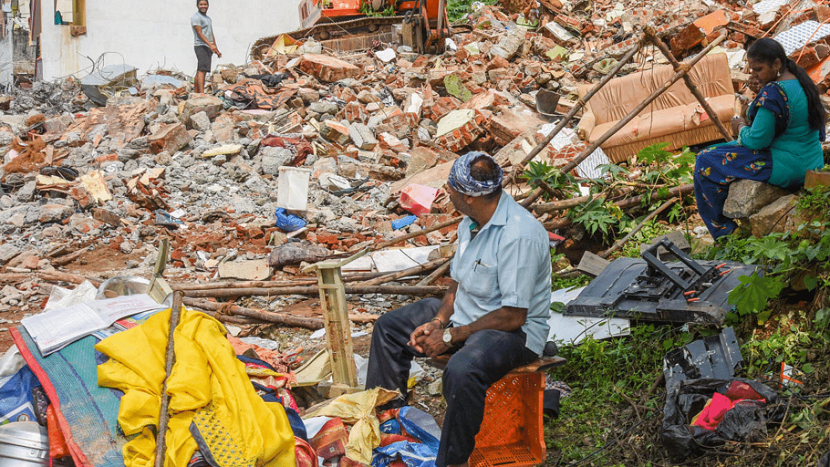 Residents at the site of what was once their home in Kamalanagar, Bengaluru. Credit: DH Photo