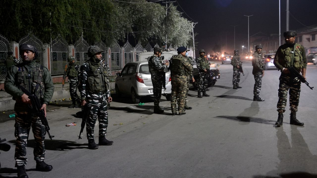 Security forces inspect the spot where militants shot dead a civilian in Srinagar, Saturday. Credit: PTI File Photo