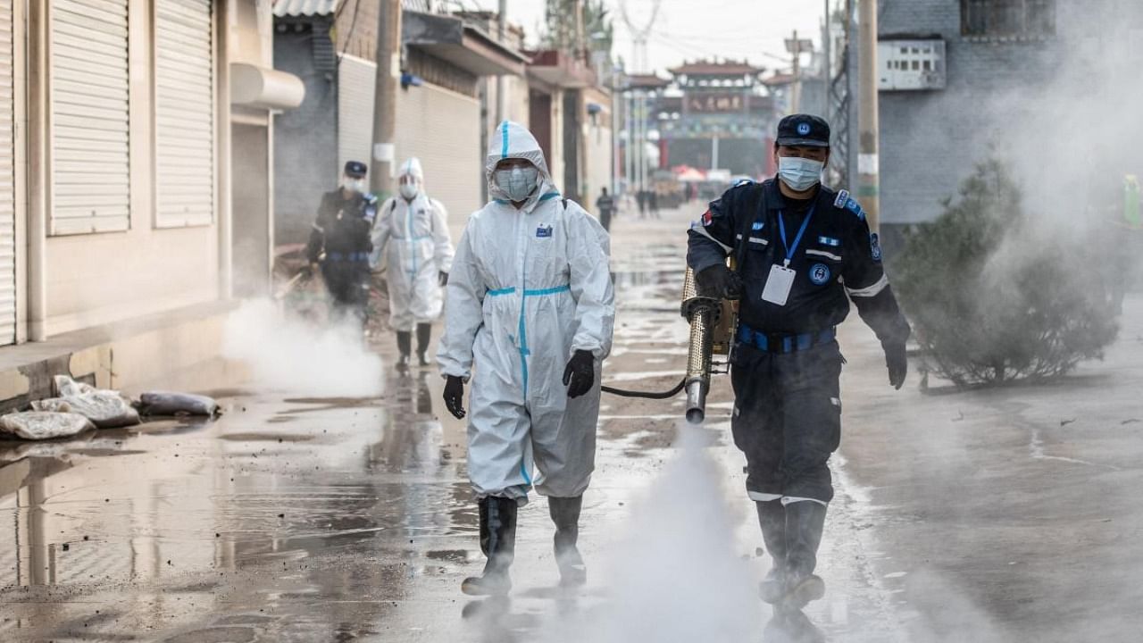 Staff members spray disinfectant in China's northern Shanxi province. Credit: AFP Photo