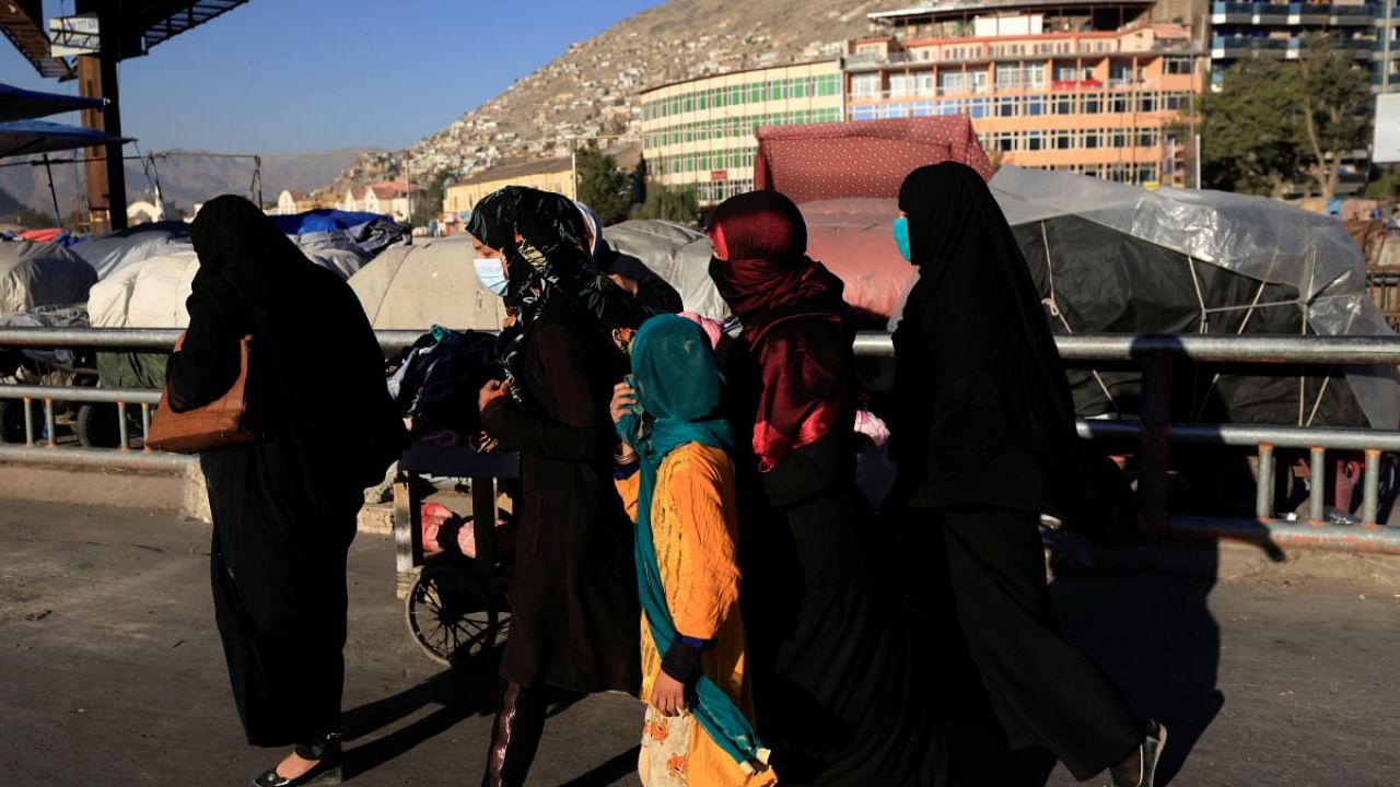 Women walk together at Pole Bagh Omomy market in Kabul, Afghanistan. Credit: Reuters Photo