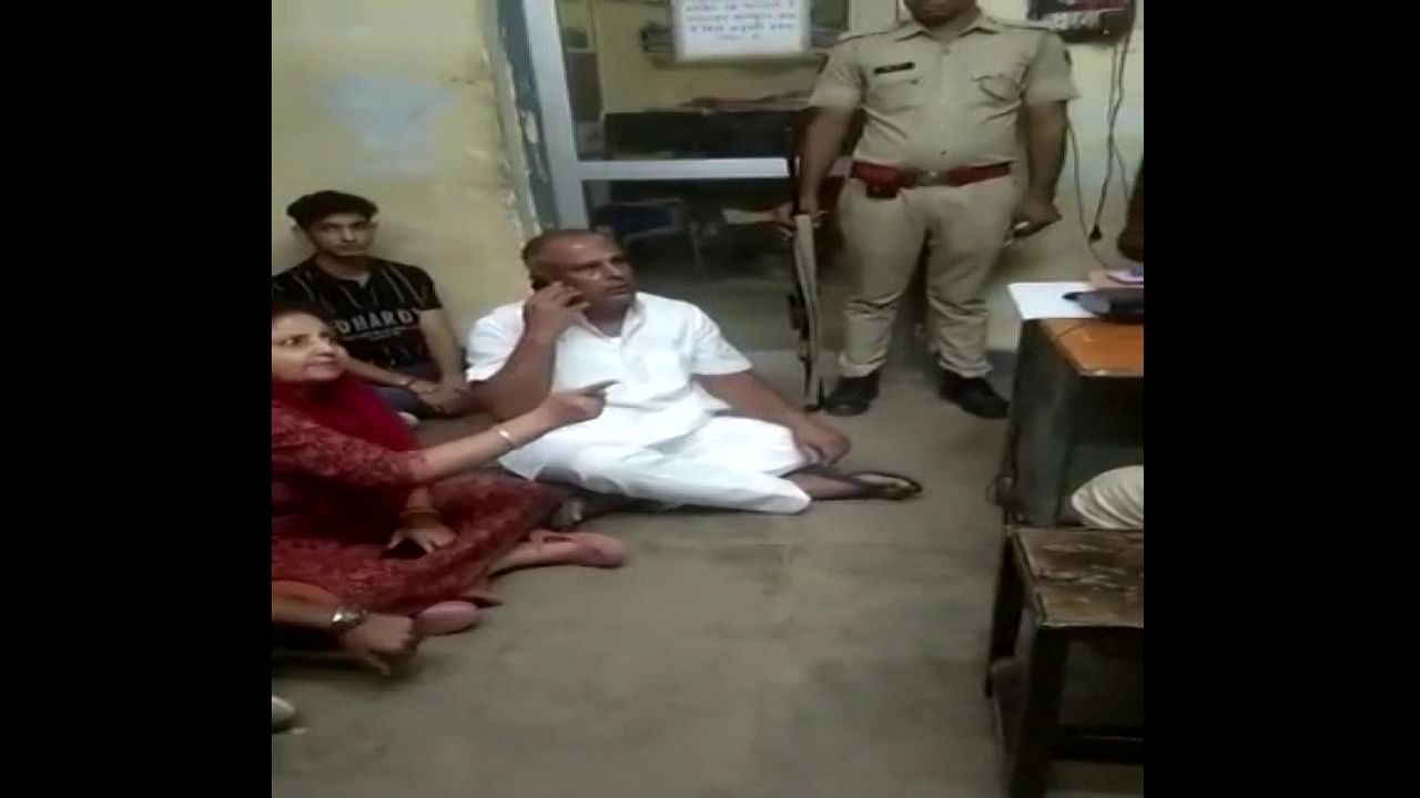 They sat on the floor of the police station in a bid to pressurise the policemen. Credit: ANI Screengrab