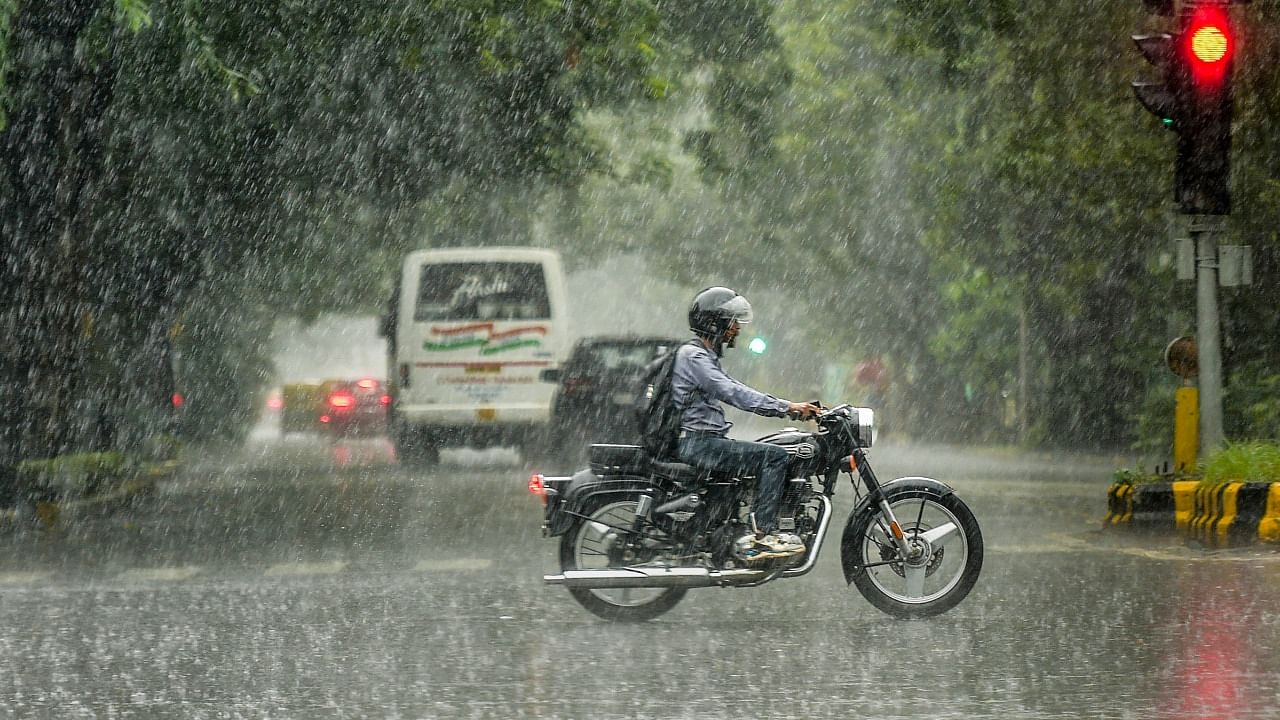 A motorcyclist rides through heavy rain in New Delhi, Sunday. Credit: PTI Photo