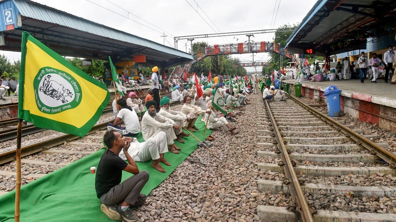 Farmers block railway tracks as part of the Samyukt Kisan Morcha's 'Rail Roko' protest demanding the dismissal and arrest of Union Minister Ajay Mishra in connection with the Oct. 3 violence in Lakhimpur Kheri. Credit: PTI File Photo