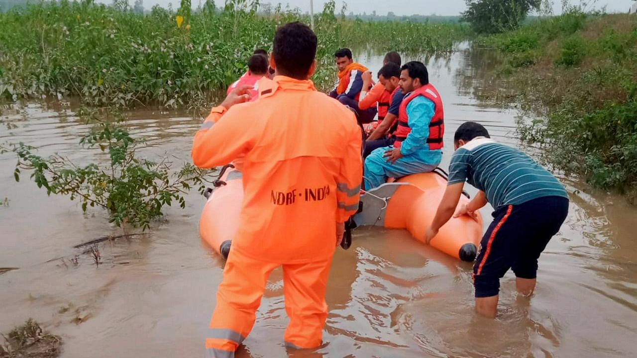 NDRF personnel evacuate people from a flooded area after heavy rains in Rudrapur, Tuesday, October 19, 2021. Credit: Twitter/@satyaprad1