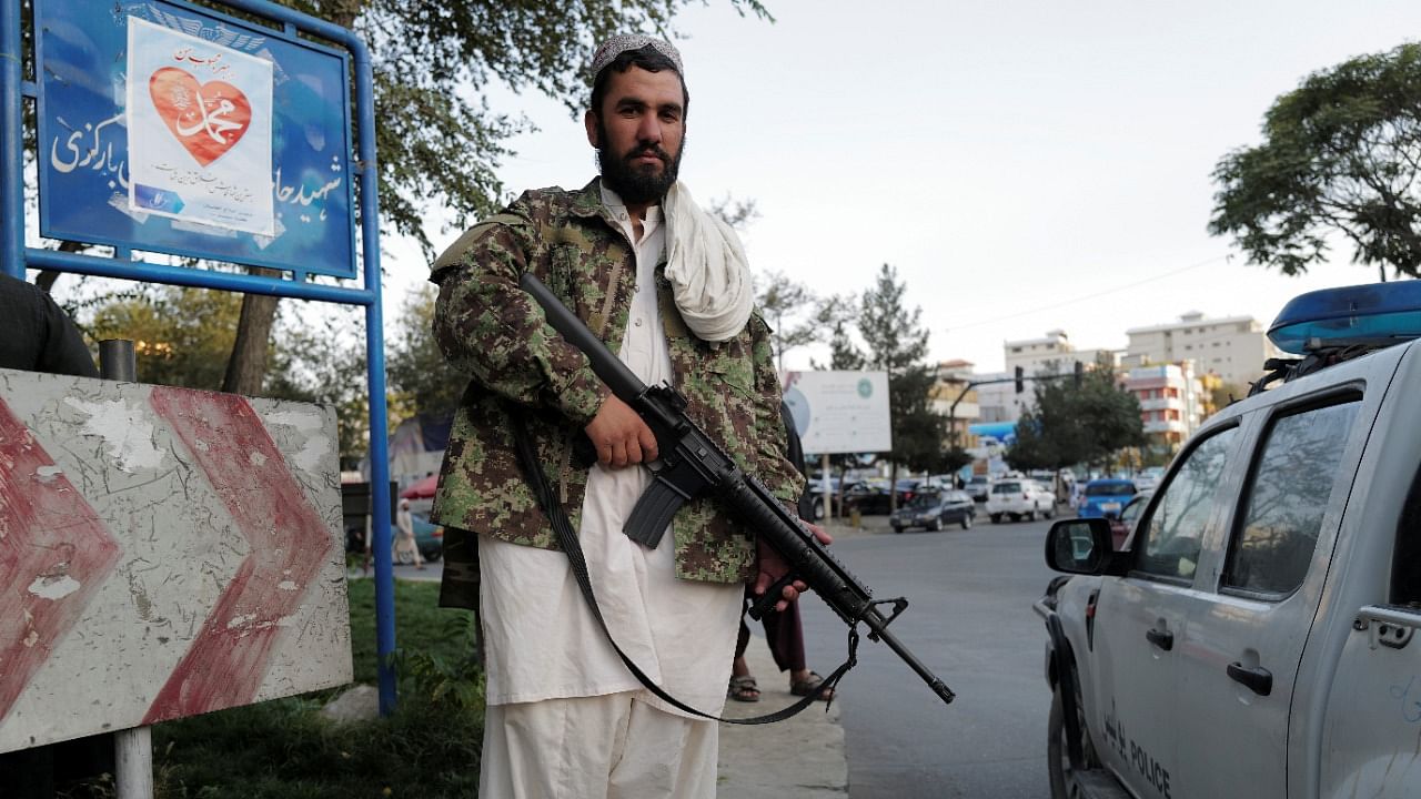 A Taliban fighter stands guard while his comrades are praying at Deh Bori square in Kabul. Credit: Reuters File Photo