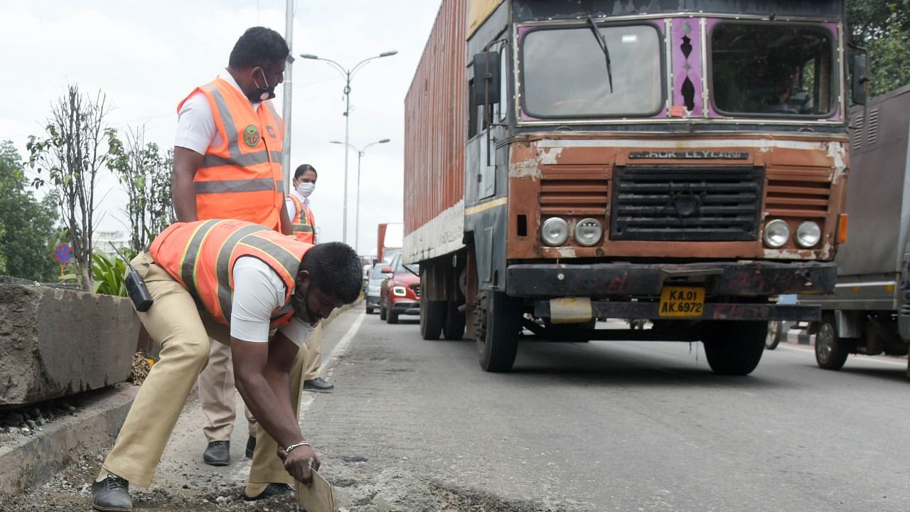 A file picture of traffic cops filling potholes in Yeshwantpur, Bengaluru. DH Photo